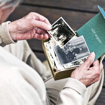 A senior's hands holding photographs, guided by CP&M LLP's probate attorneys for estate administration and disputes resolution.
